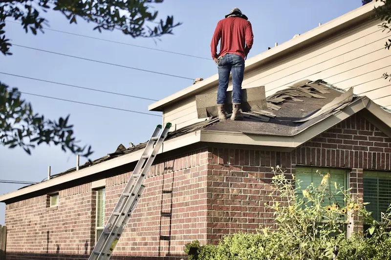 Professional roofer working on a residential roof in Old Brookville